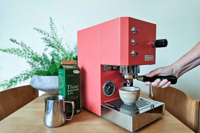 Haand holder om bajonet paa pink espressomaskine klar til barista teknik kursus