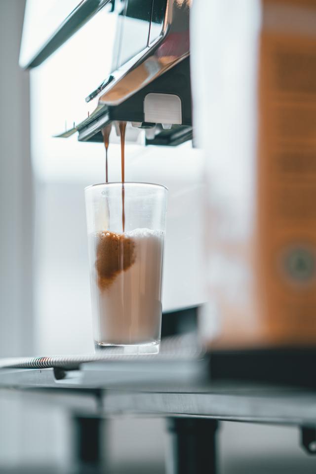 kaffe med maelk bliver brygget paa kaffemaskine