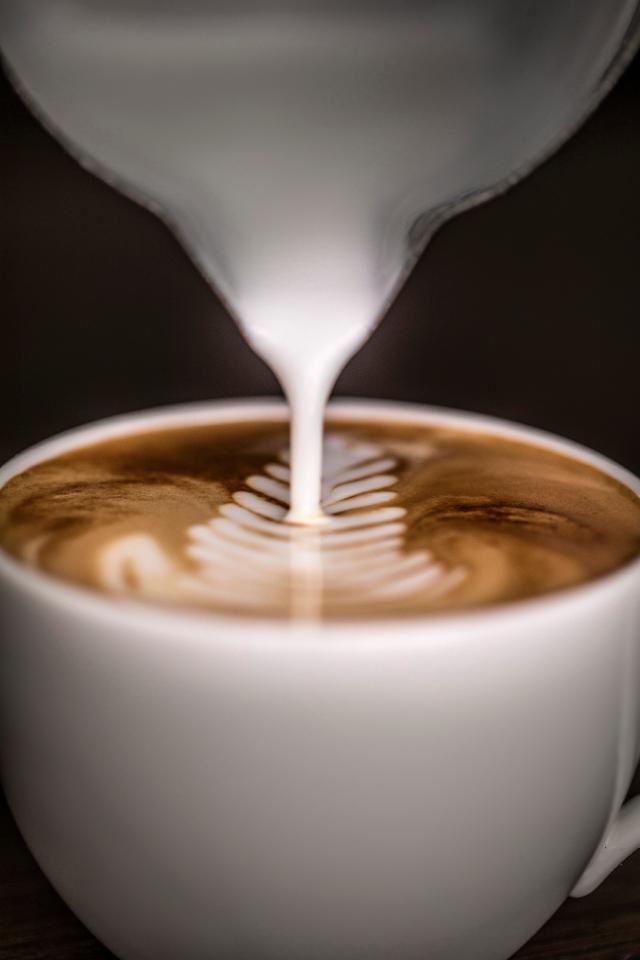 steamet maelk haeldes ud af kande og ned i kaffe til flot latteart