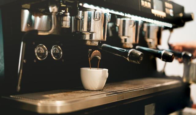Der brygges en dobbeltespresso ned i en kop på en stor professionel espressomaskine